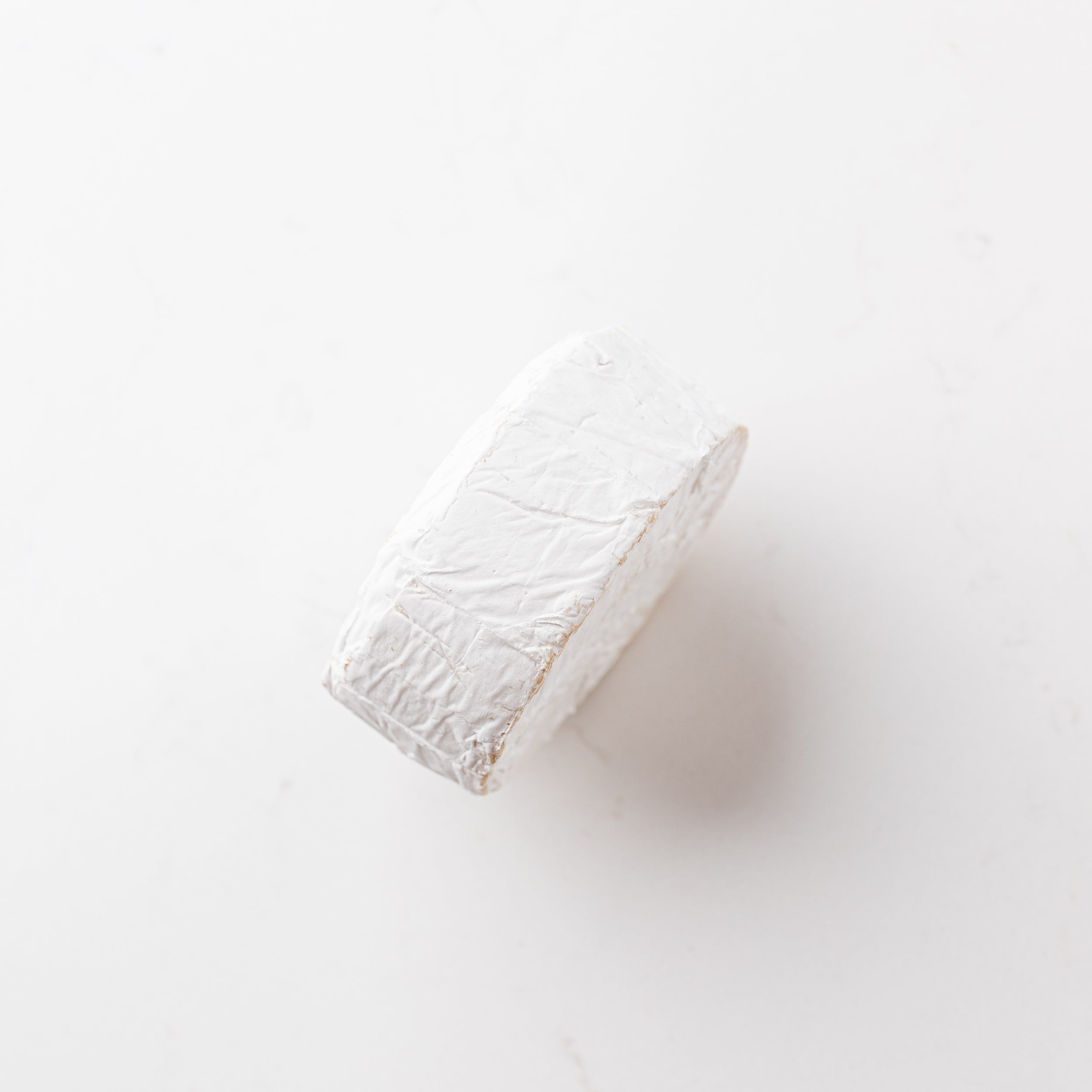 A block of cheese on a plain white background.