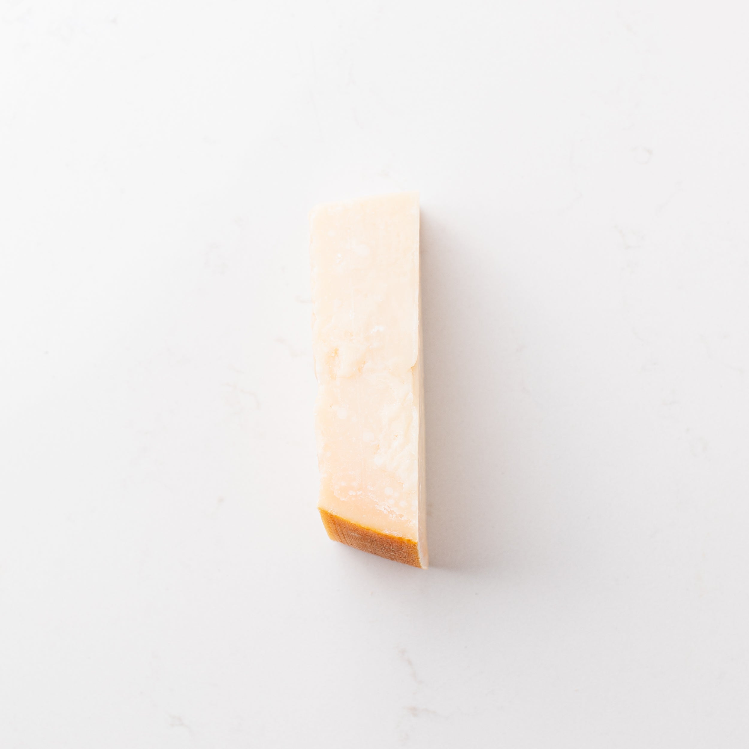 A block of cheese on a plain white background.
