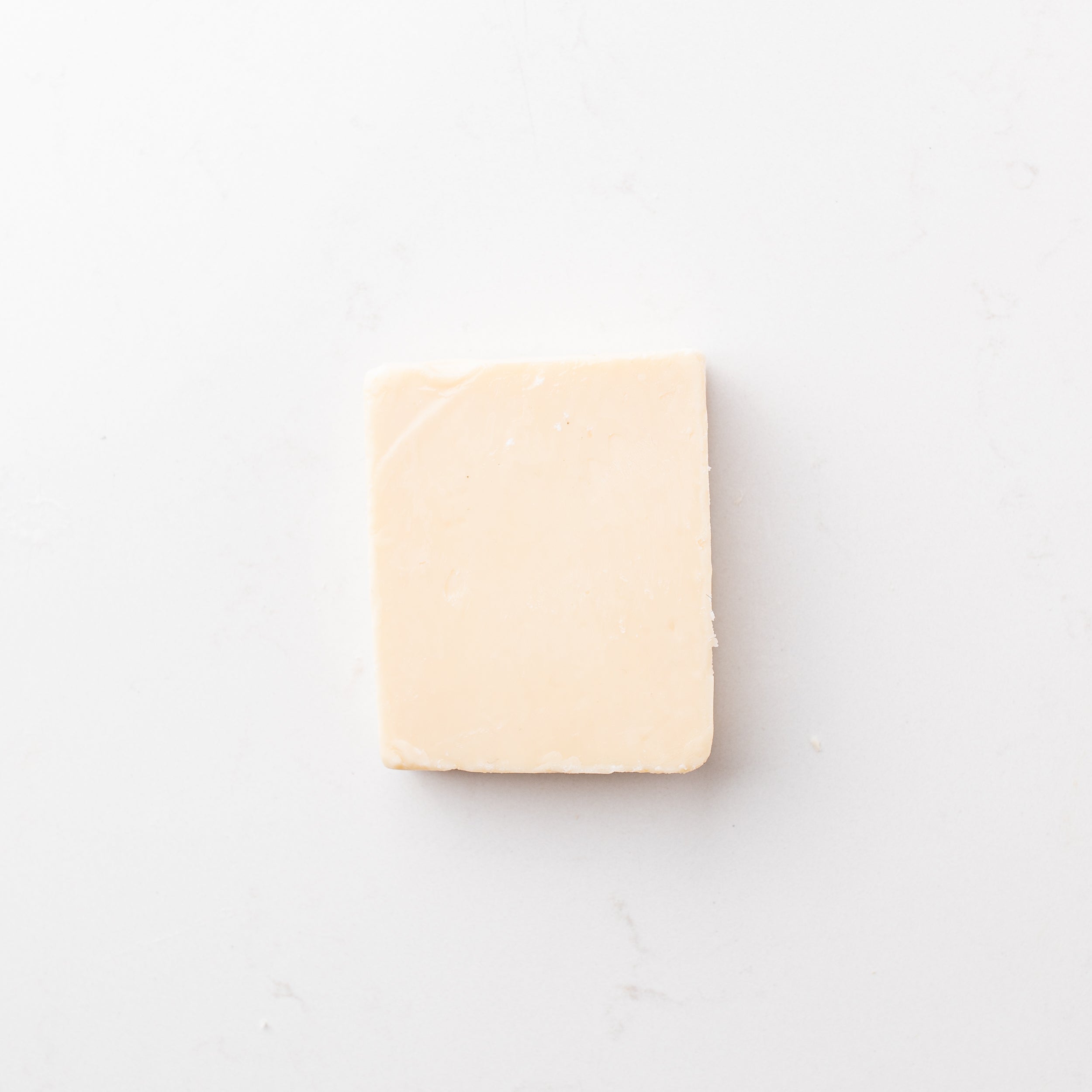 A block of white cheese on a plain white background.