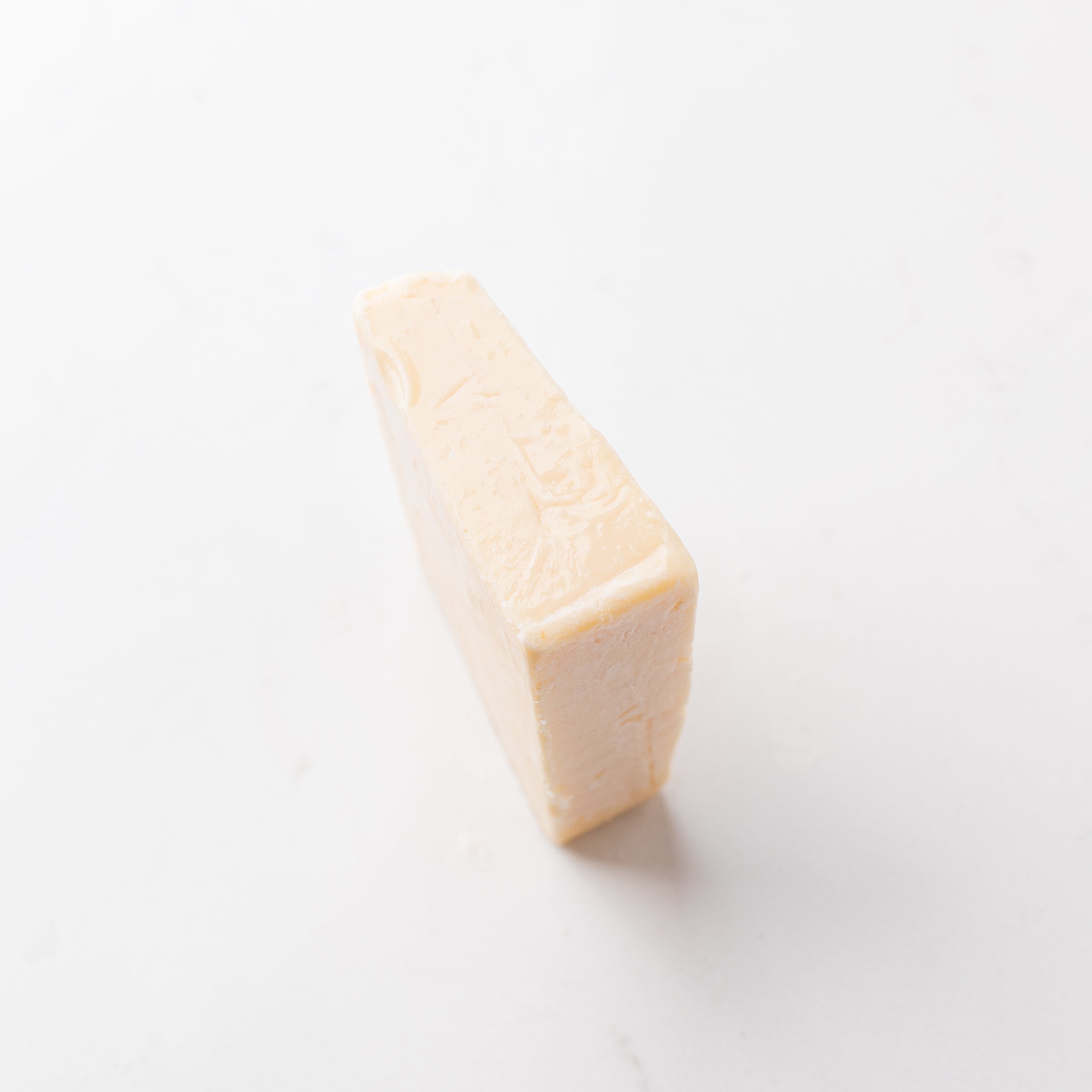 A block of white cheese on a plain white background.
