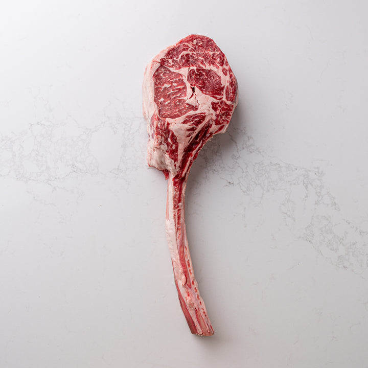A visually impressive tomahawk steak, sourced locally and naturally, on display at the butcher shoppe.
