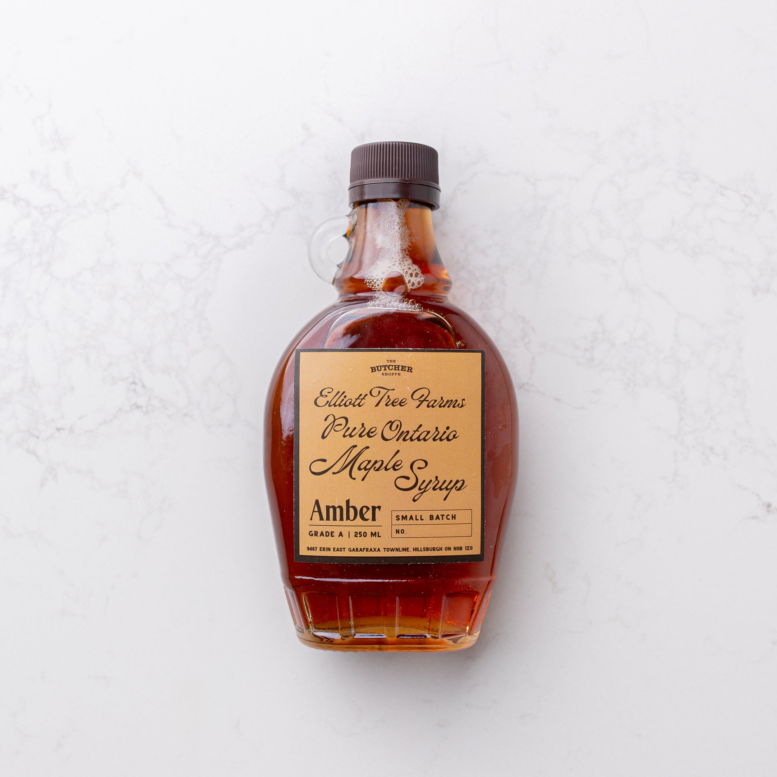 Rich and golden maple syrup on display at The Butcher Shoppe, offering a touch of sweetness to culinary delights.