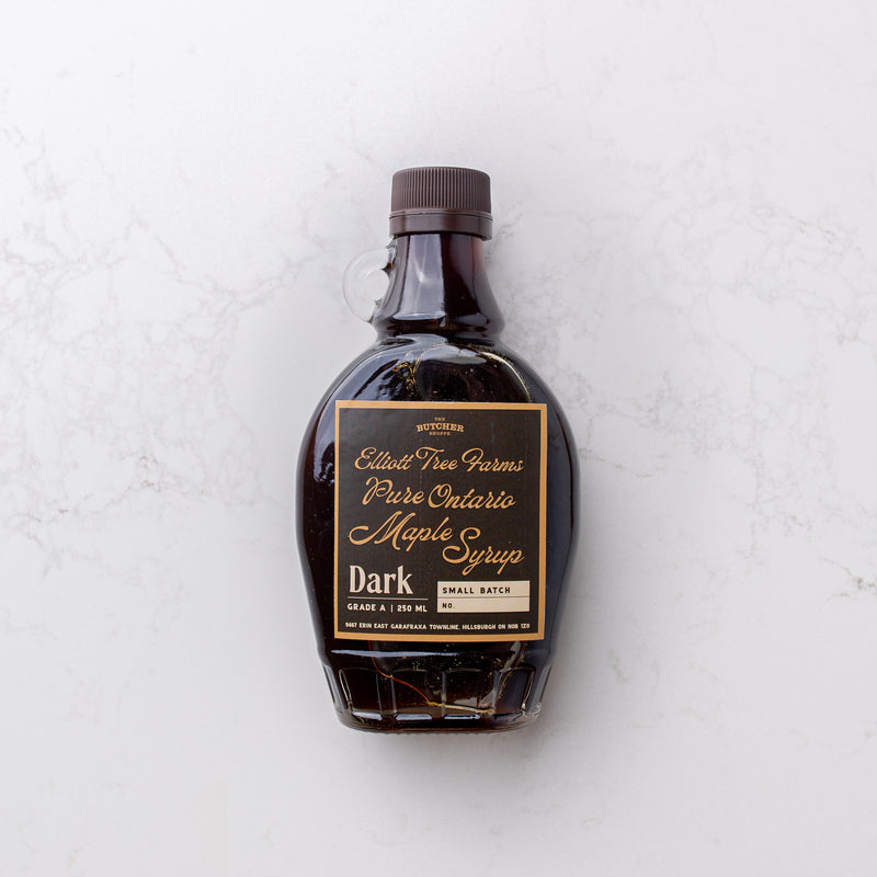 Rich and golden maple syrup on display at The Butcher Shoppe, offering a touch of sweetness to culinary delights.